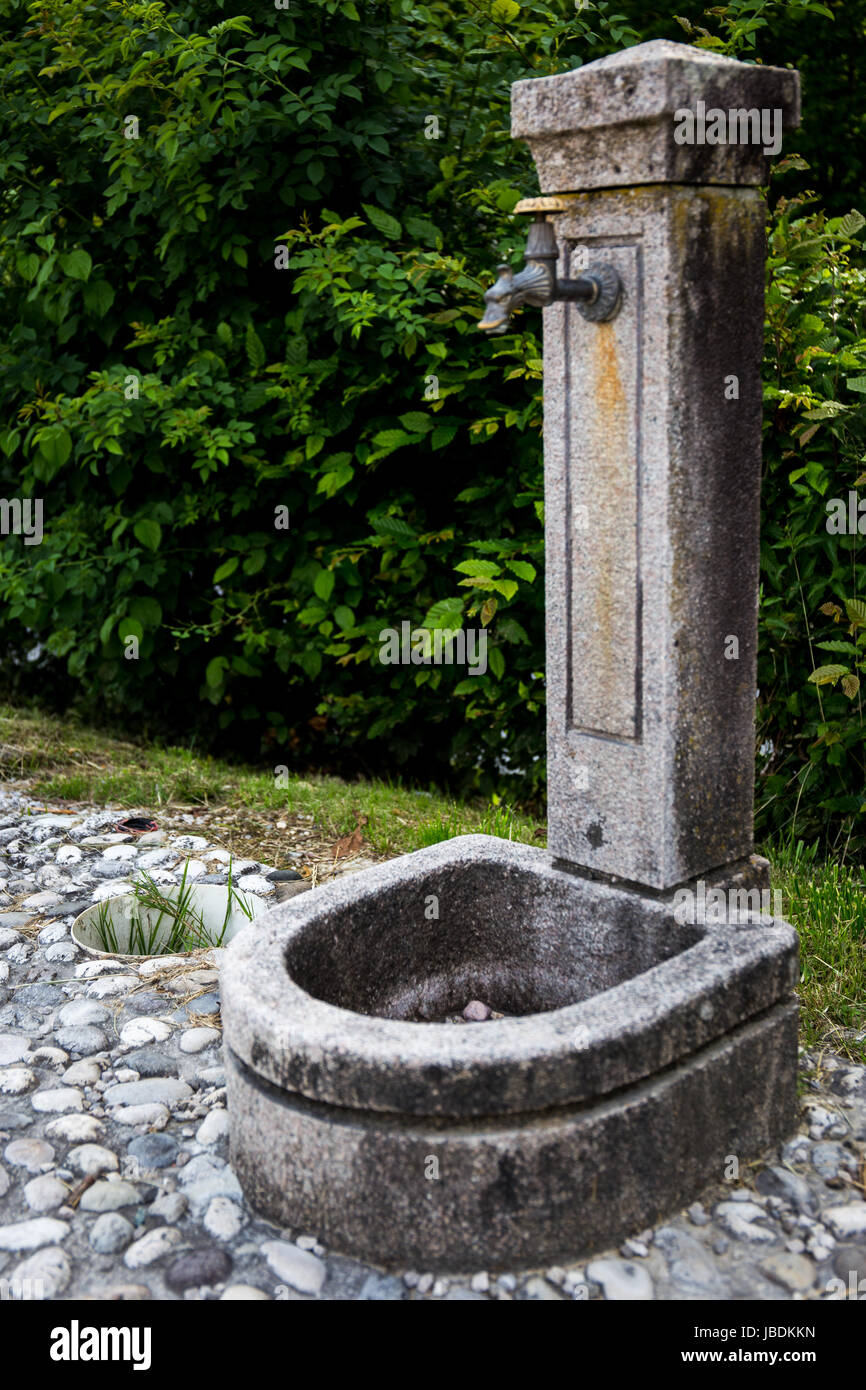 Una fuente de agua potable en un pavimento de piedra Foto de stock