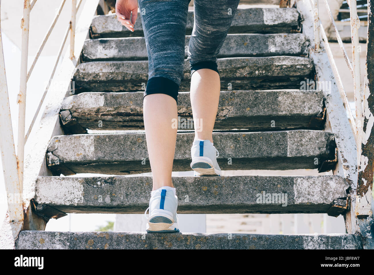 Chica delgada en zapatillas y ropa deportiva para subir escaleras, close-up,  baja angular Fotografía de stock - Alamy