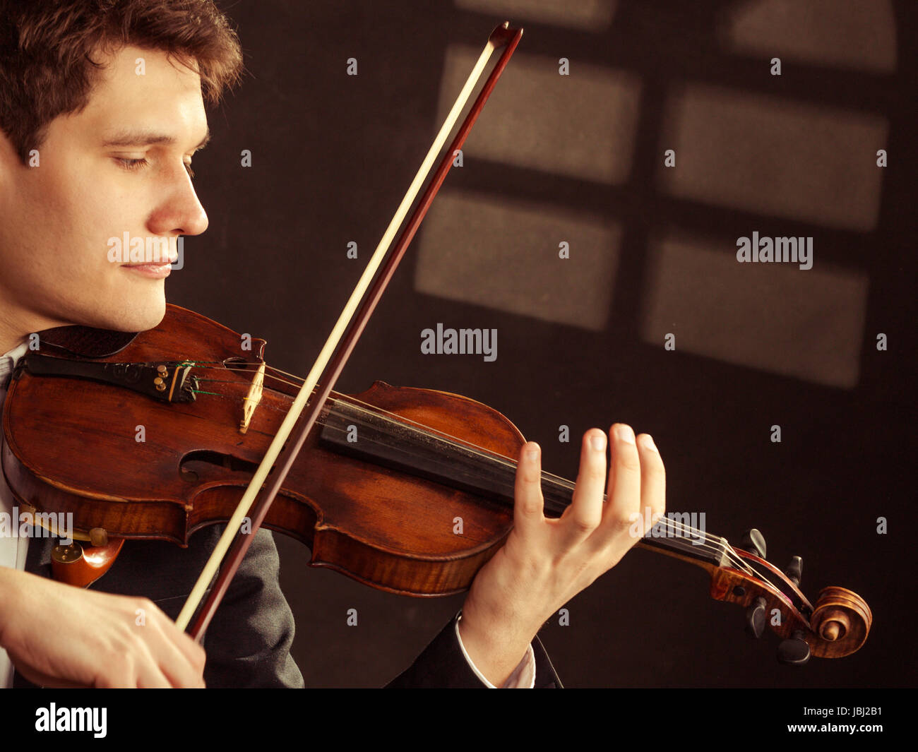 El arte y el artista. En el amor el hombre elegante joven violinista  violinista a tocar el violín bajo la ventana por la noche. La música clásica.  Foto de estudio Fotografía de