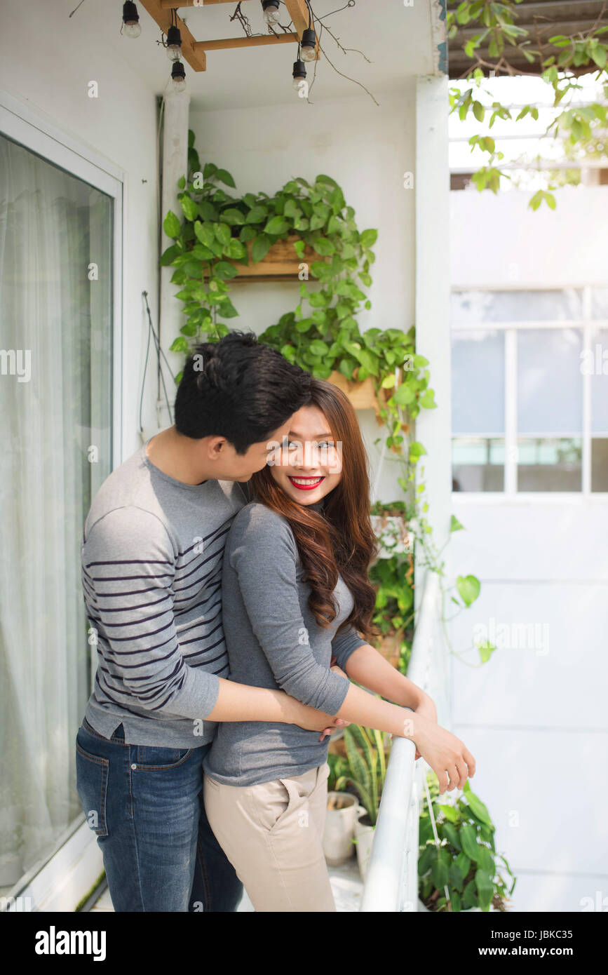 Pareja en el amor y la felicidad genuina emociones compartir, abrazarse en el balcón Foto de stock