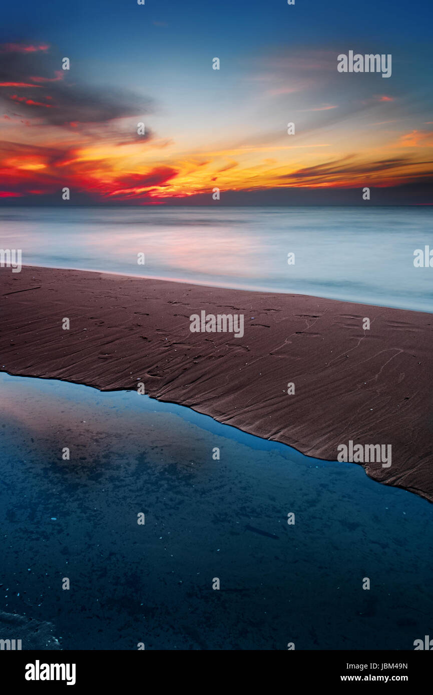 Hermoso colorido atardecer en la playa del mar Báltico. Olas borrosa por la larga exposición. La Bahía de Gdansk, Pomerania, Polonia. Foto de stock