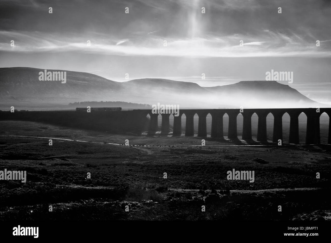 Norte de ferrocarril 1151 Carlisle - Leeds pases de tren Ribblehead viaduct con Ingleborough detrás Foto de stock