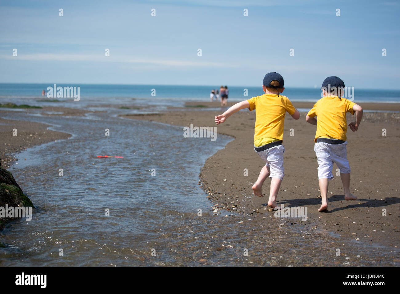 Gemelos huyendo de la vista sobre la playa de Devon Foto de stock