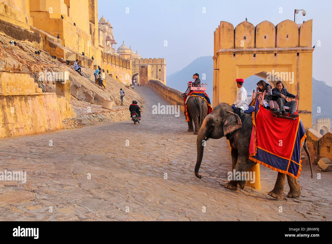 Decorado con elefantes turistas va en el camino empedrado a Fuerte Amber, cerca de Jaipur, Rajasthan, India. Los paseos en elefante son populares atracciones attrac Foto de stock