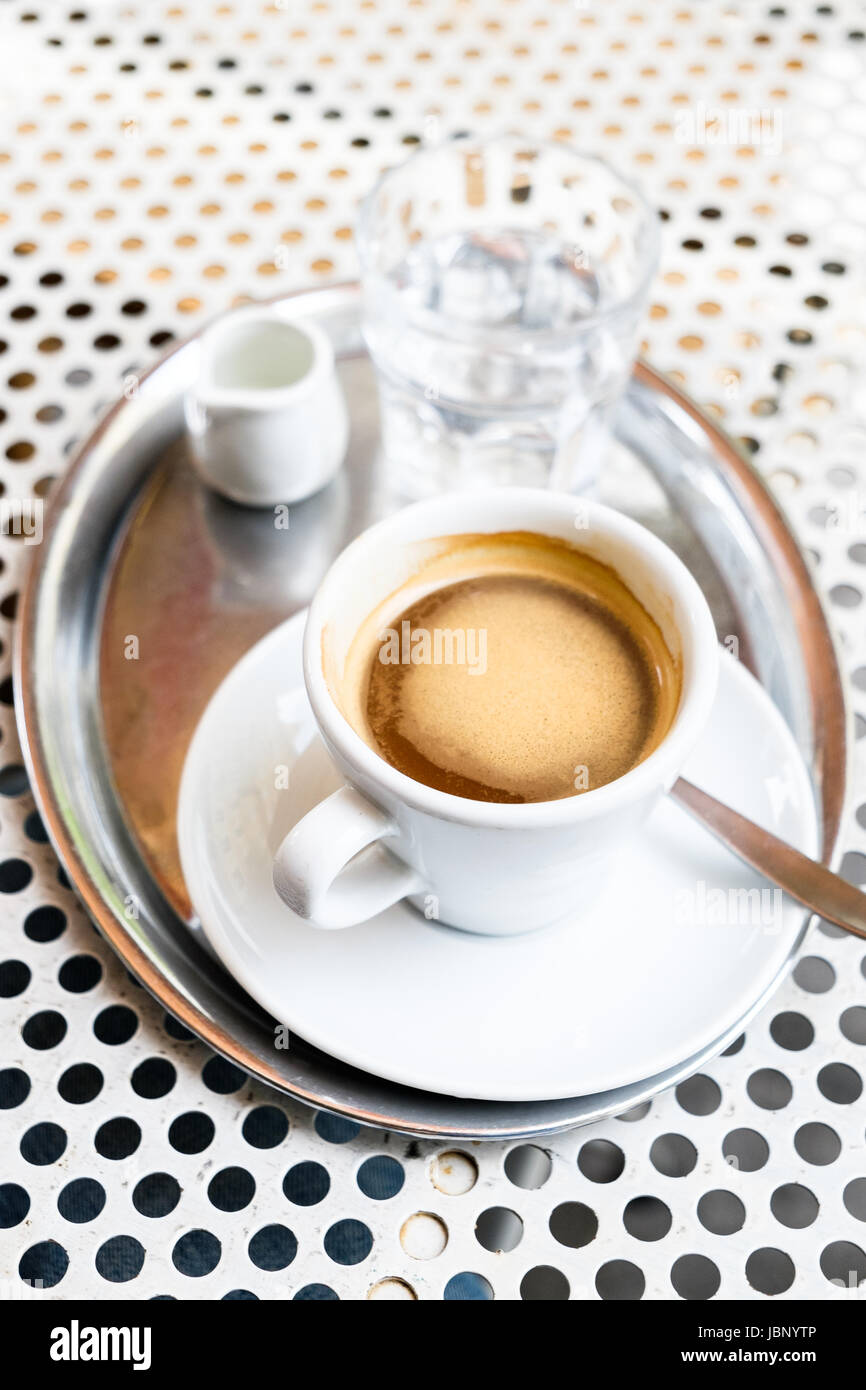 Un café en la terraza de un café vienés - un "Großer / grosser brauner' o un café negro con la leche servida en el lateral. Foto de stock