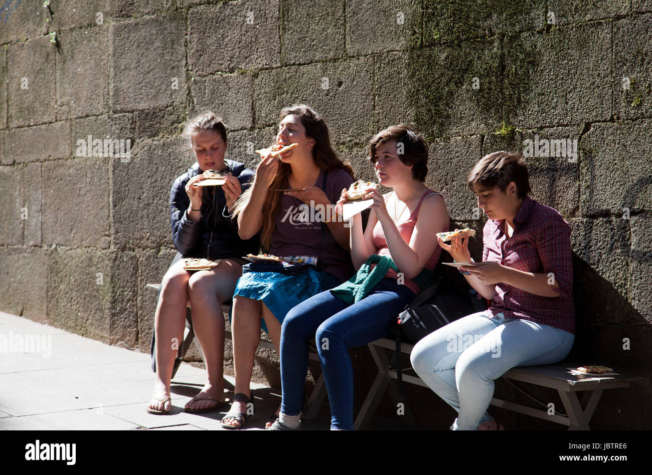 Los adolescentes comer pizza en la Rua Dos Clerigos Bench en Porto - Portugal Foto de stock
