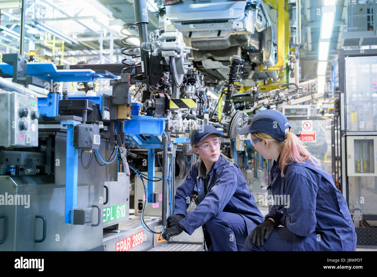 Ingenieros de mantenimiento de mujeres trabajando en la línea de producción en la fábrica de automóviles Foto de stock