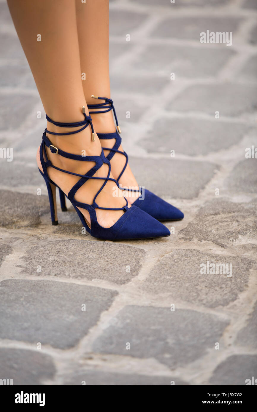 Cerca de los pies de una mujer vistiendo elegnat tacones azul en carretera  adoquinada Fotografía de stock - Alamy