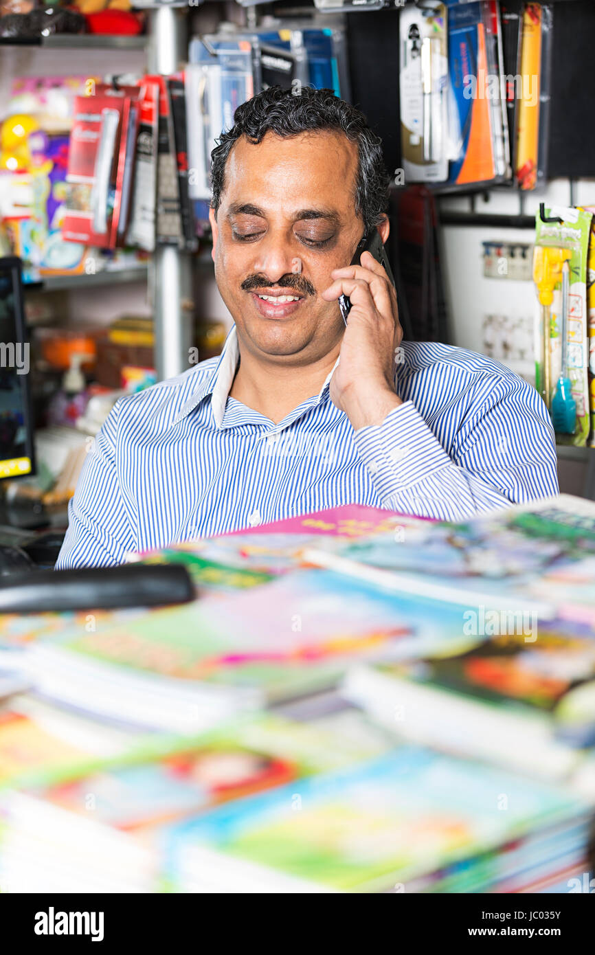 1 tendero indio hombre hablando por teléfono móvil en papelería Foto de stock