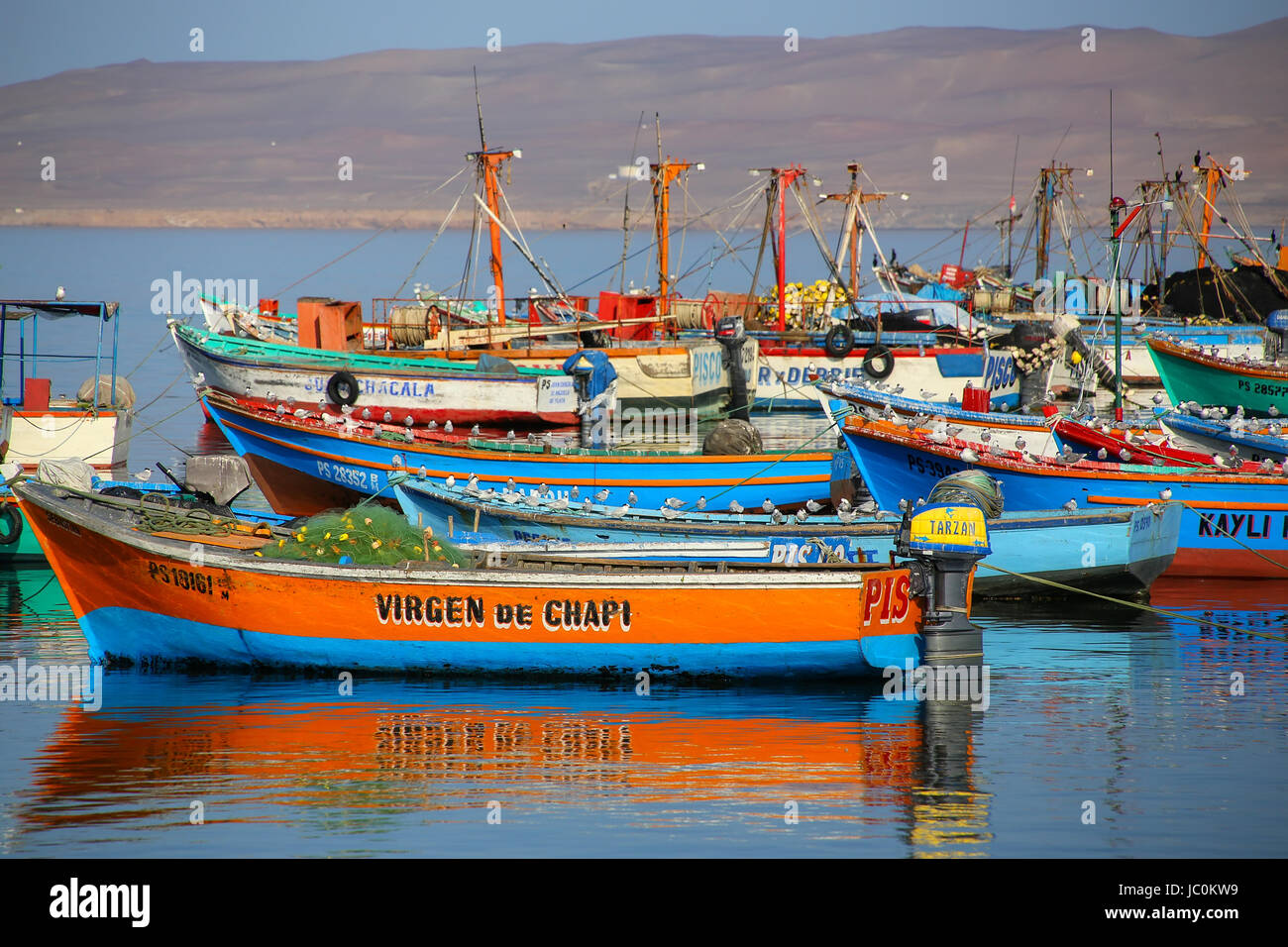 Coloridos botes de pesca anclados en la Bahía de Paracas, Perú. Paracas es  una pequeña ciudad portuaria atienden a los turistas que visitan la Reserva  de Paracas y las islas Ballestas Fotografía