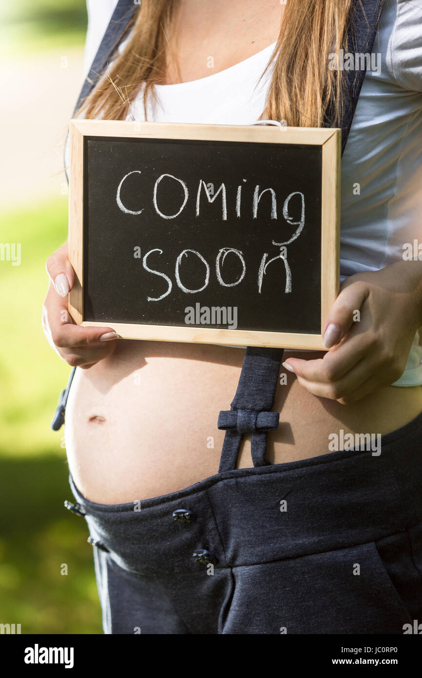 Captura conceptual de la mujer embarazada la celebración de pizarra con el  texto "Próximamente Fotografía de stock - Alamy