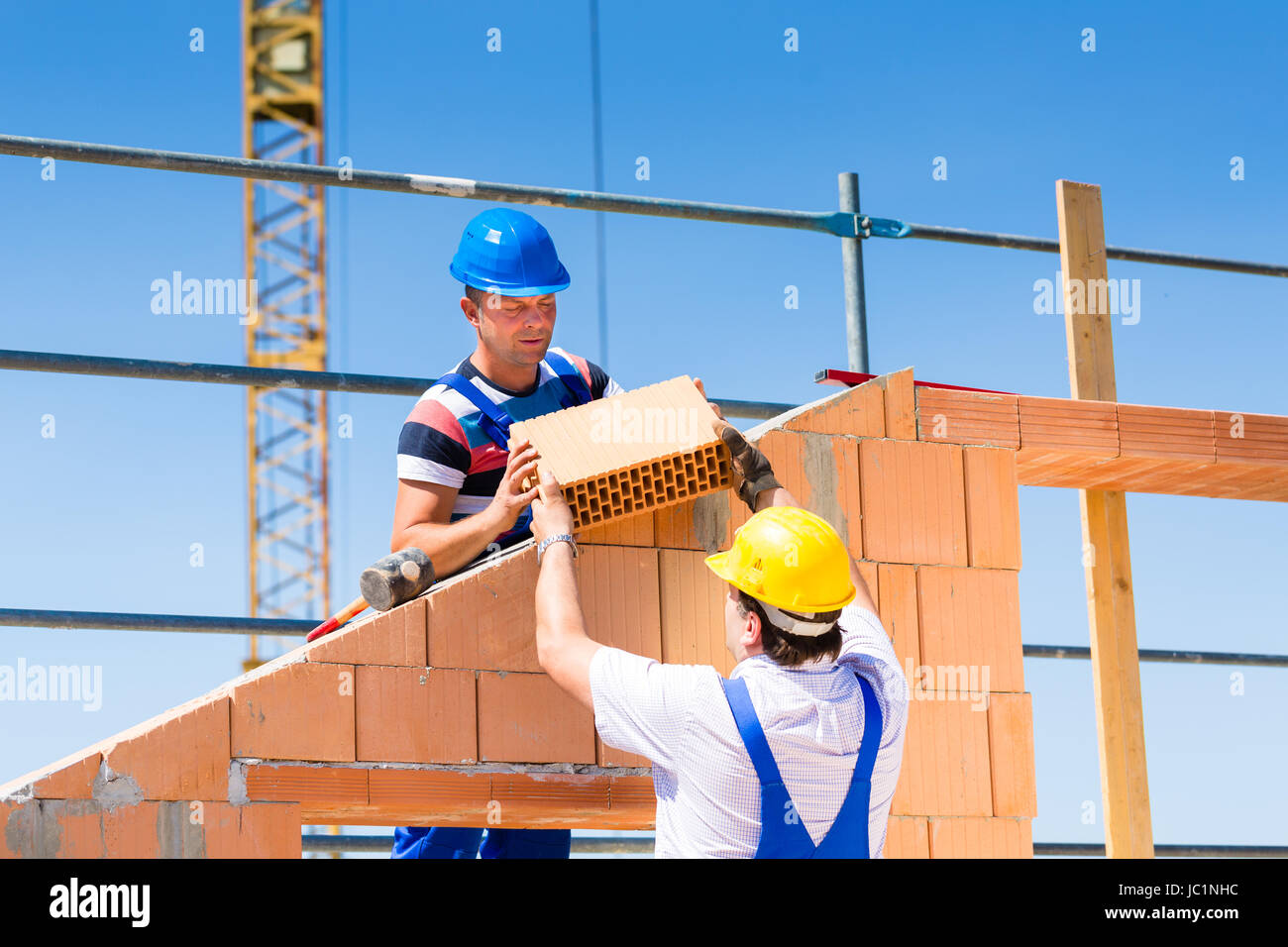 Dos albañil o constructor o trabajador bricklaying o construir o diseñar un  muro de piedra o ladrillo en la construcción o sitio en construcción  Fotografía de stock - Alamy