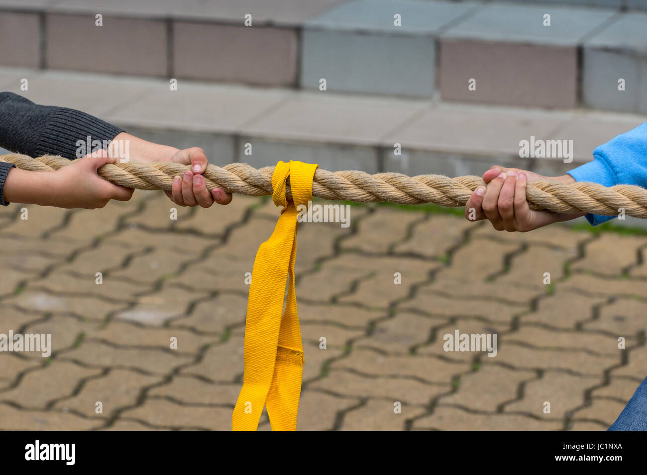 Los niños tirando de la cuerda - cierre en manos de jóvenes competidores Foto de stock