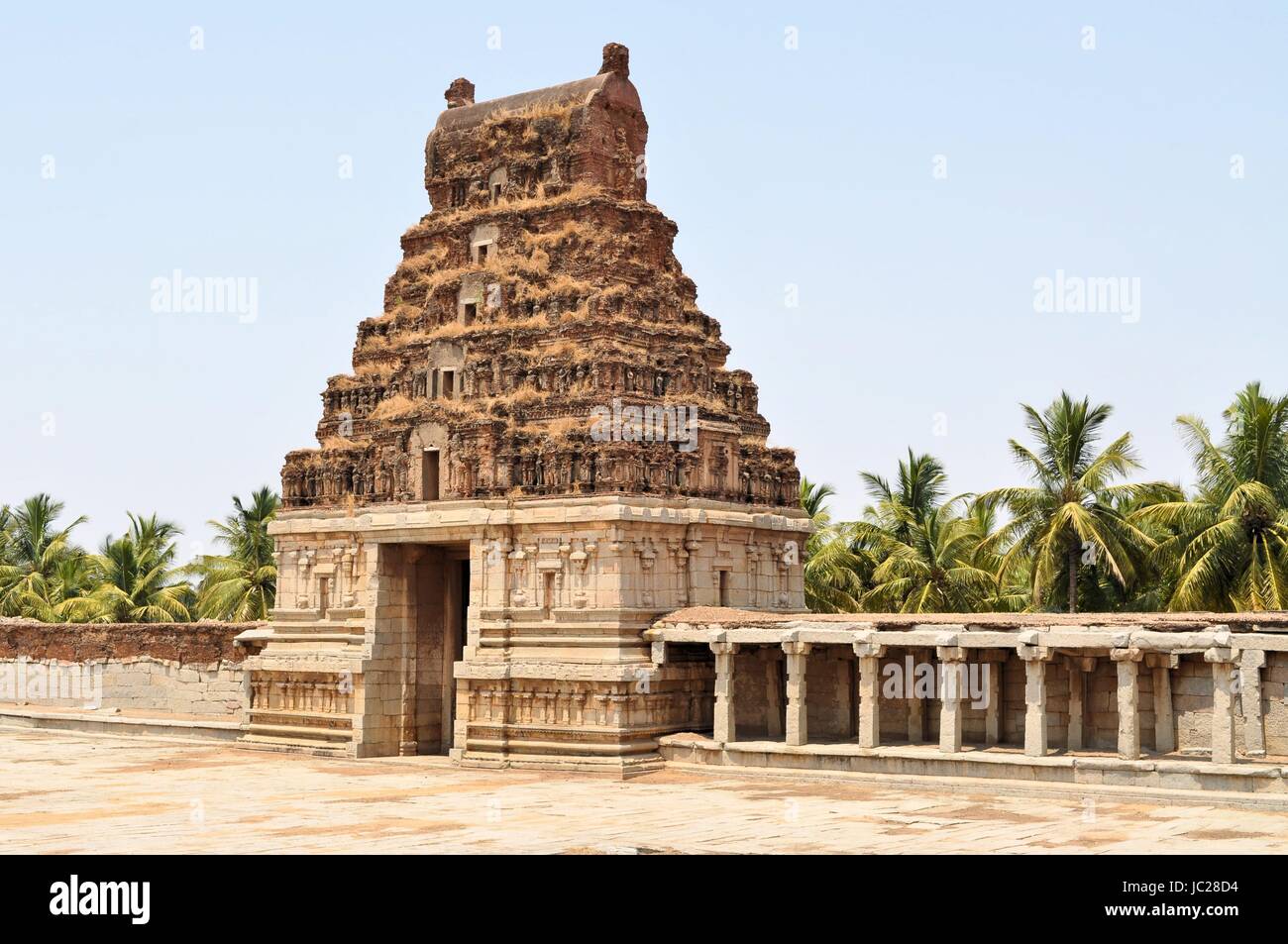 Las antiguas ruinas del Imperio Vijayanagara partiallyovergrown al atardecer cielo azul en Hampi, Karnataka, India Foto de stock