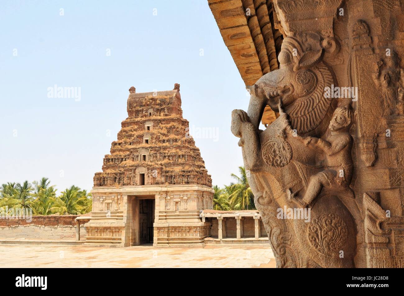 Las antiguas ruinas del Imperio Vijayanagara partiallyovergrown al atardecer cielo azul en Hampi, Karnataka, India Foto de stock