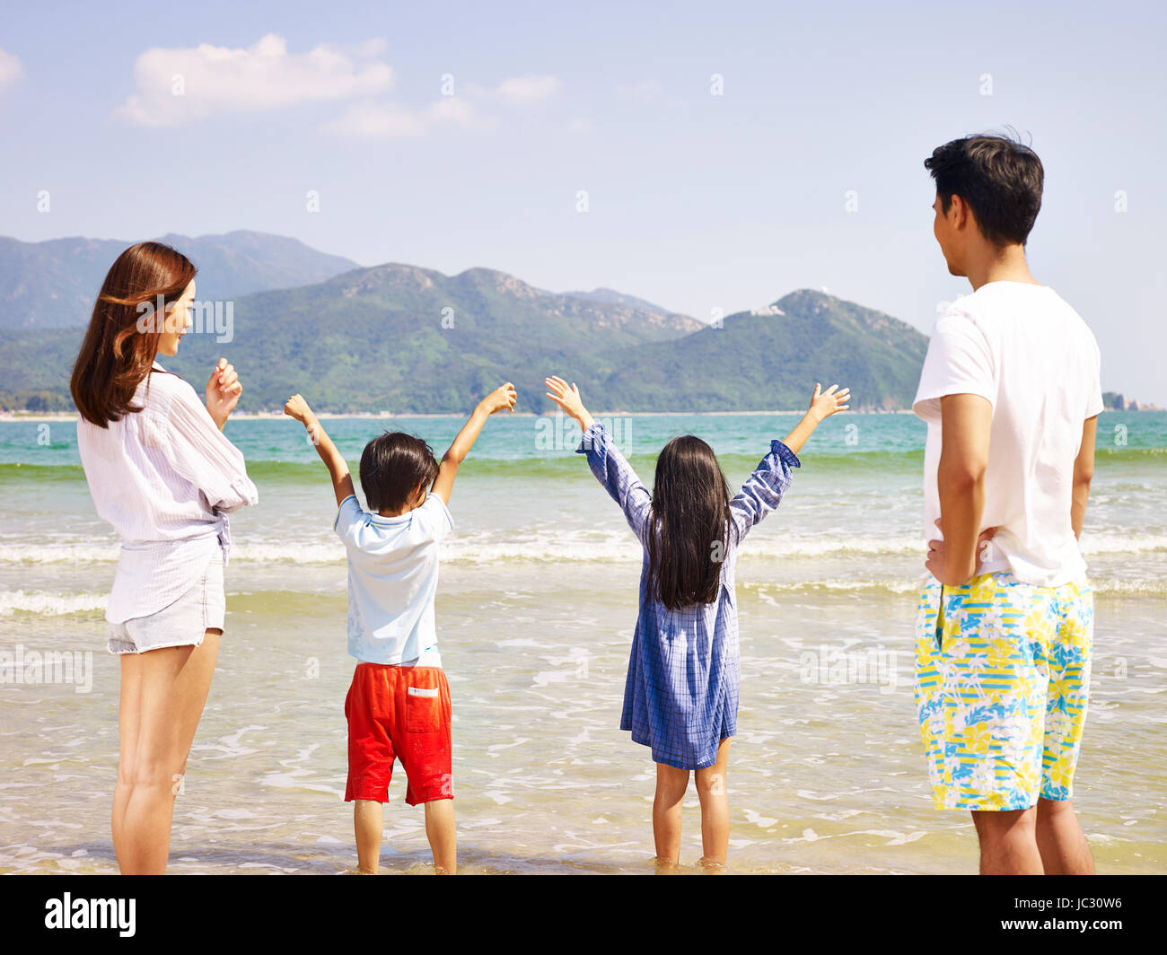 Familia de Asia con dos niños divirtiéndose en la playa. Foto de stock