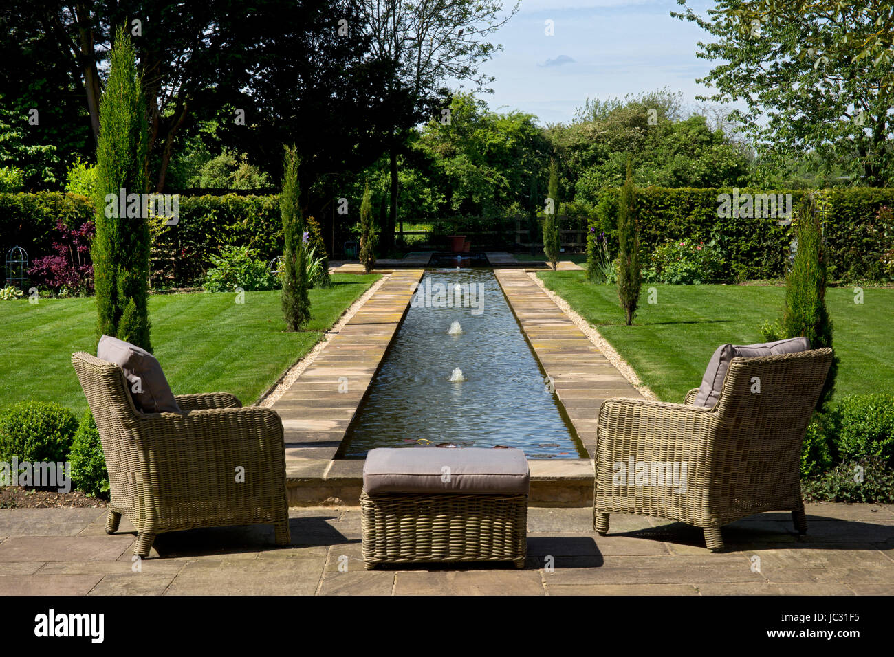 Jardín Inglés con agua de Riachuelo y mimbre sillas de jardín Foto de stock