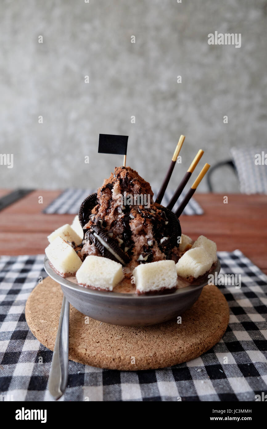 Shaved ice con almíbar y la leche, chocolate, fresa Foto de stock