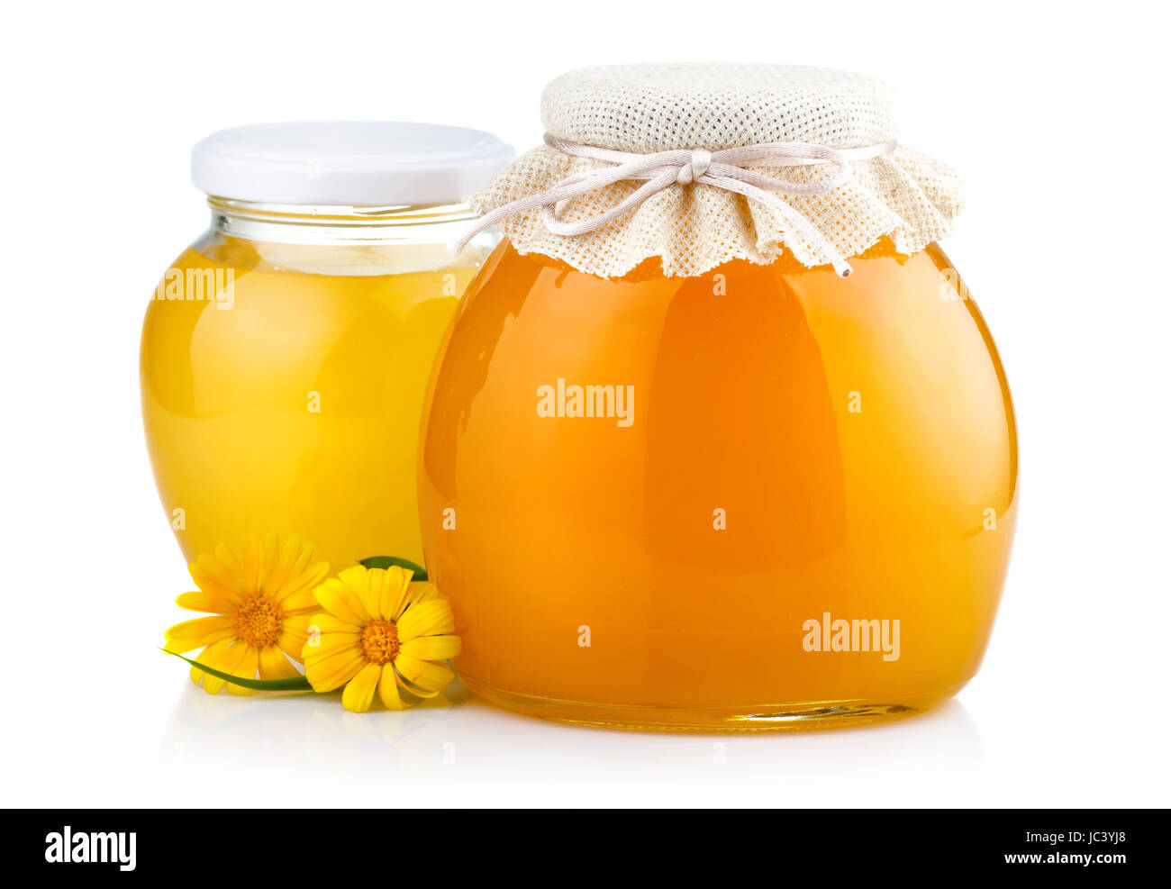 Dulce Miel en tarros de vidrio con flores aisladas sobre fondo blanco. Foto de stock