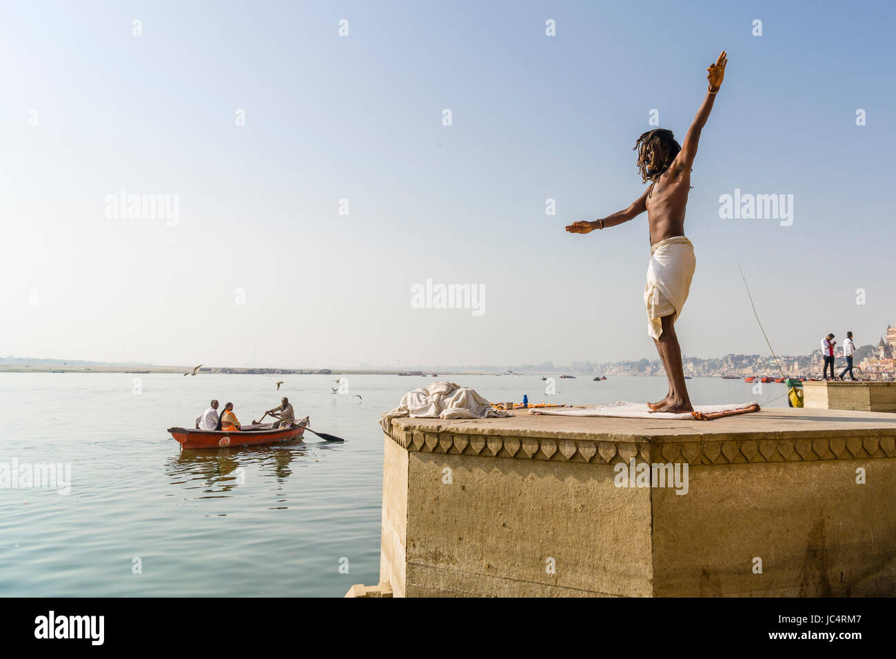 Un sadhu, hombre santo, baila sobre una plataforma en el río santo Ganges en meer ghat en el suburbio godowlia Foto de stock