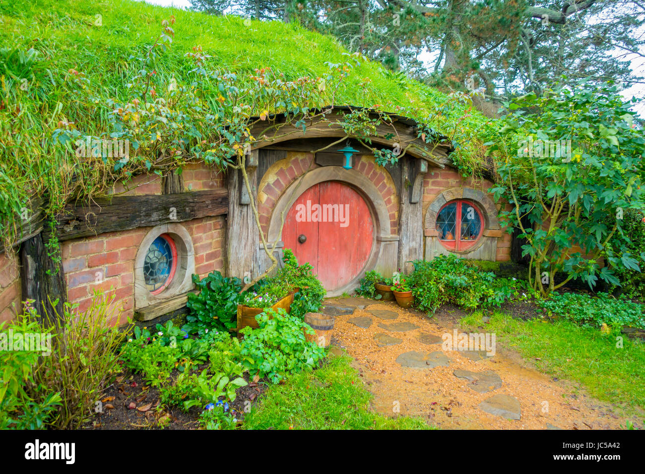 Isla del Norte, Nueva Zelanda- Mayo 16, 2017: Hobbit casa con puerta roja, hobbiton movie set, sitio para películas: El Hobbit y el señor de los anillos en Matamata Foto de stock