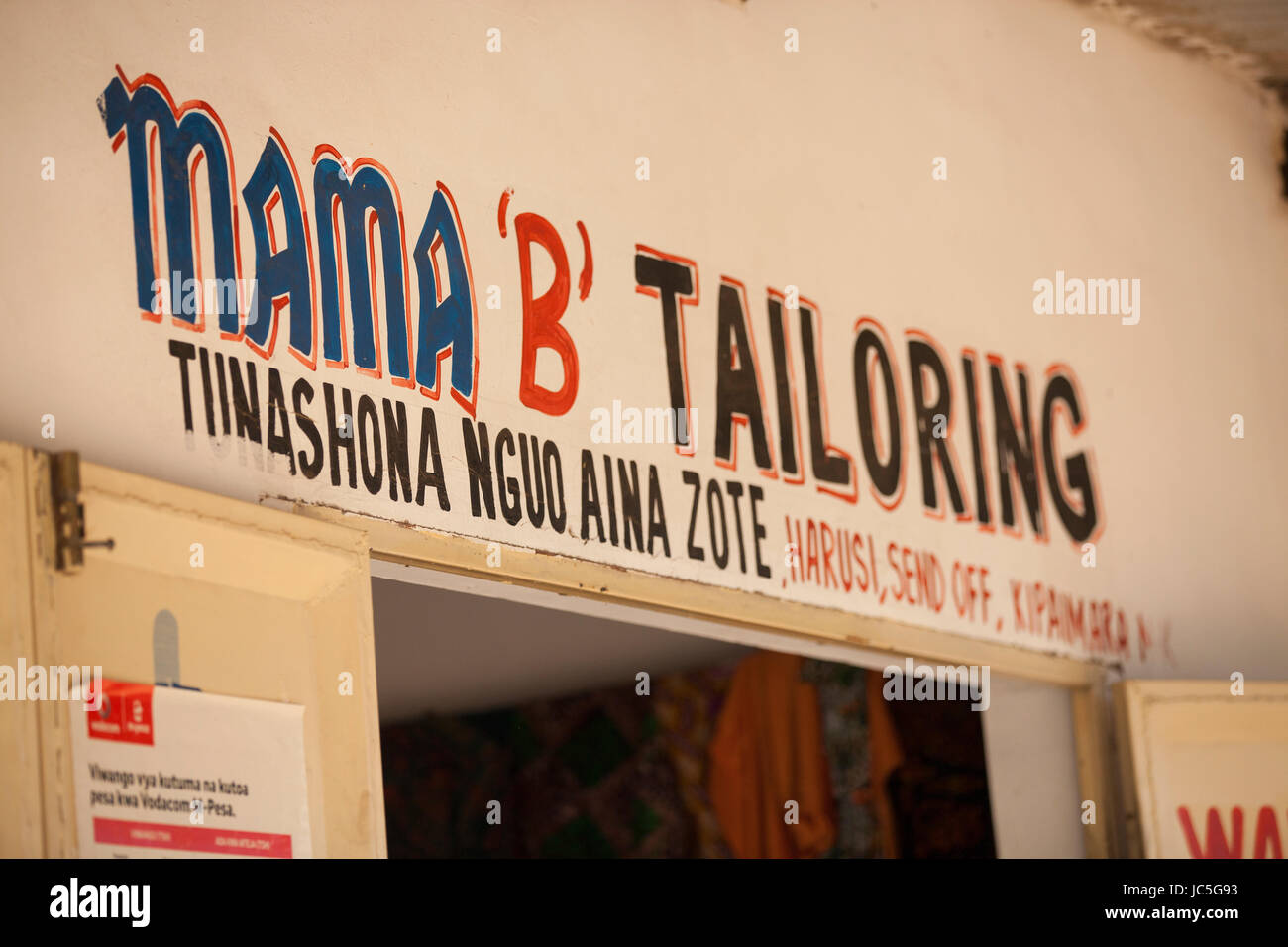 La tienda signo frente a una hembra sastrería, Tanzania, África Foto de stock