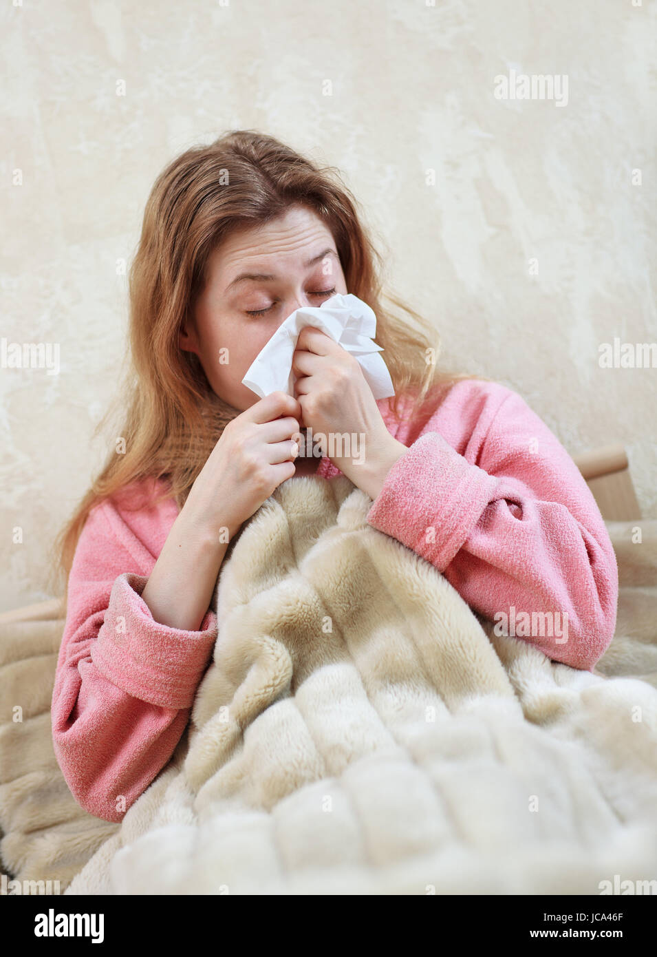 Mujer joven con gripe y rinitis acostado en la cama Foto de stock