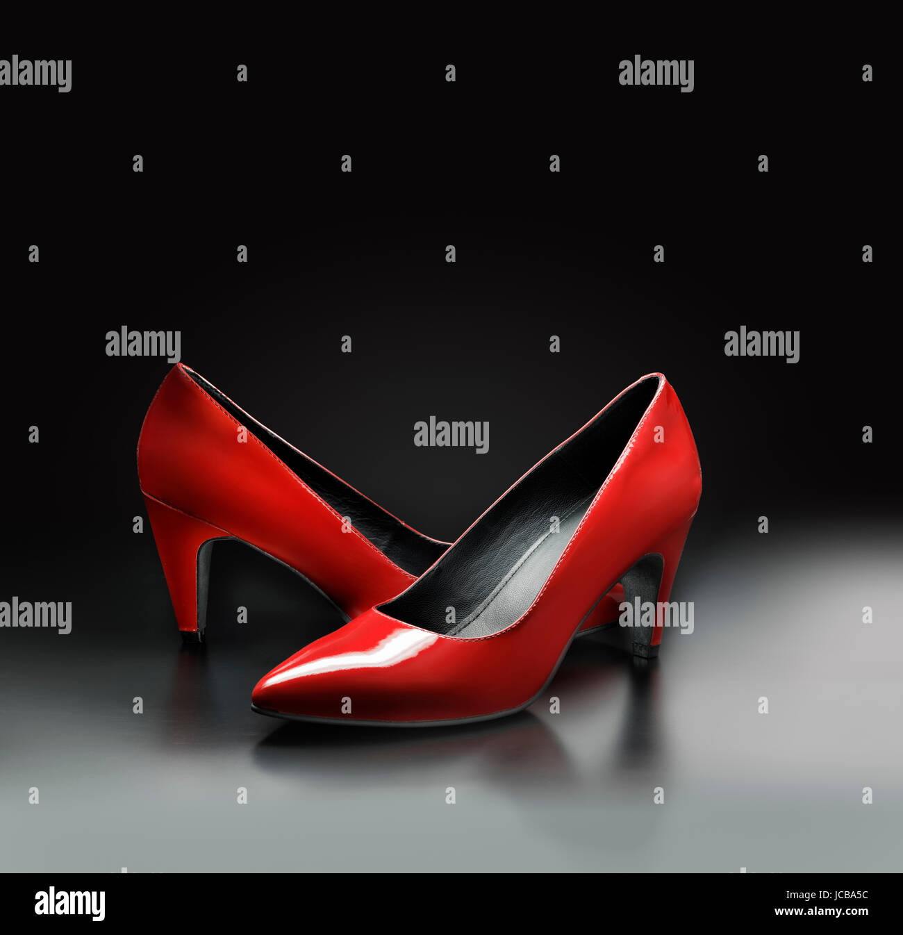 Mujer zapatos bombas de cuero rojo sobre fondo gris. Foto de stock