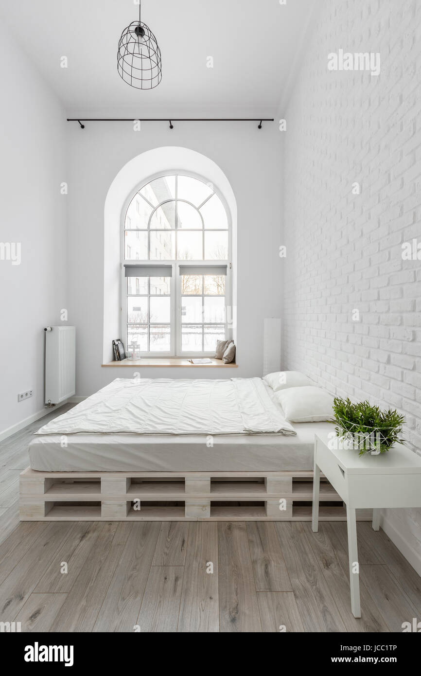 Arriba cúbico Inadecuado Dormitorio con cama de palets blancos y pared de ladrillo Fotografía de  stock - Alamy