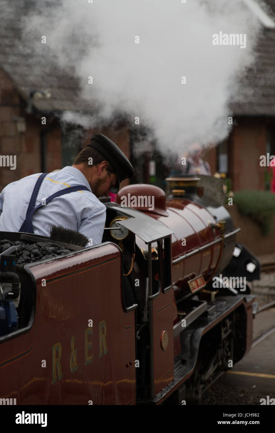 Y Ravenglass Eskdale Railway Miniature motor a vapor Río ácaro macho con conductor de tren uniformado con tapa Foto de stock