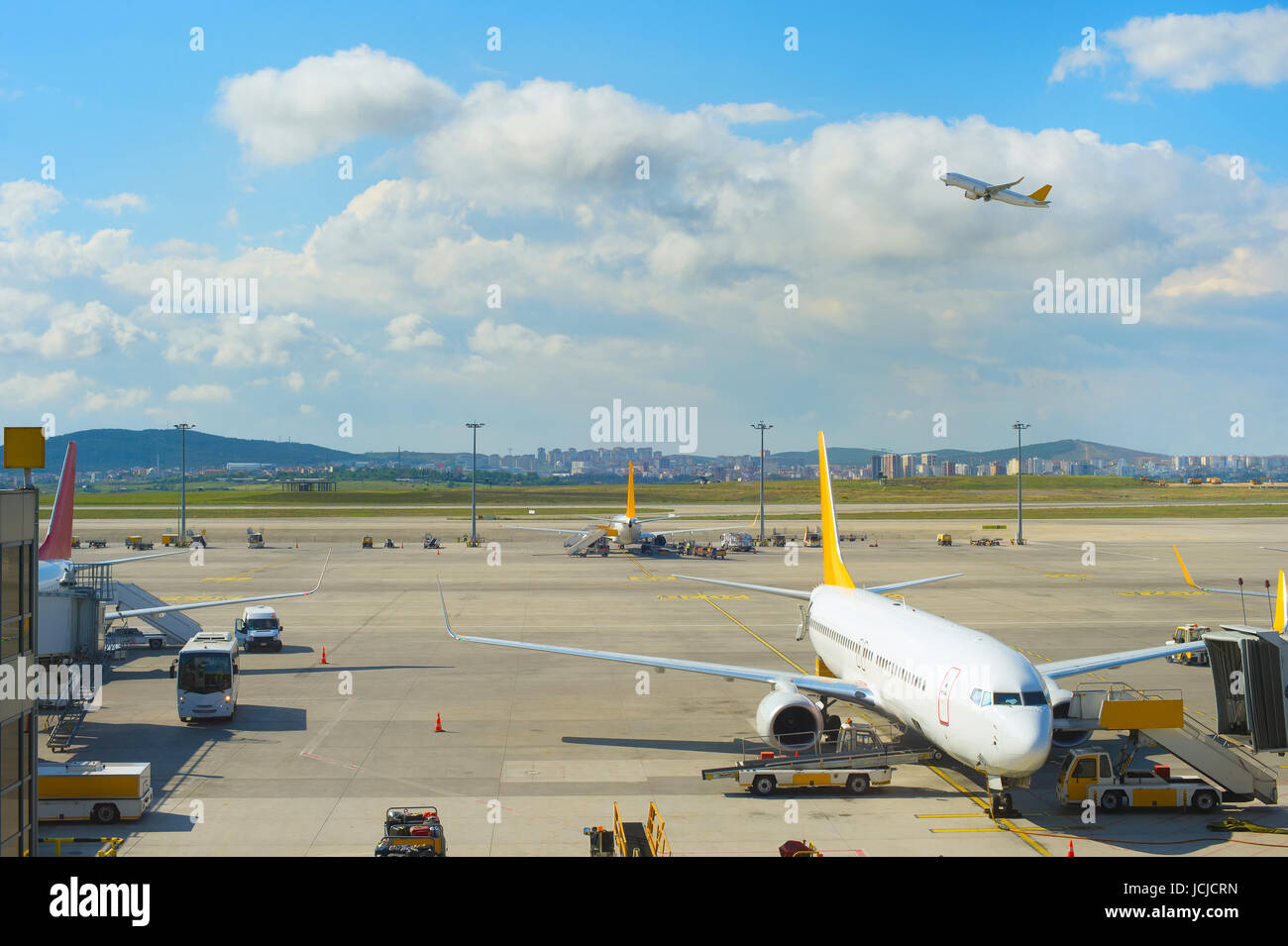 Avión despegando en el aeropuerto, mientras que el otro avión bajo carga Foto de stock