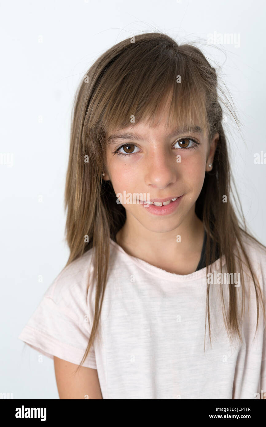 Retrato de niña de 10 años con rostro serio sobre un fondo blanco. Toma con  luz natural que entra a través de una ventana Fotografía de stock - Alamy