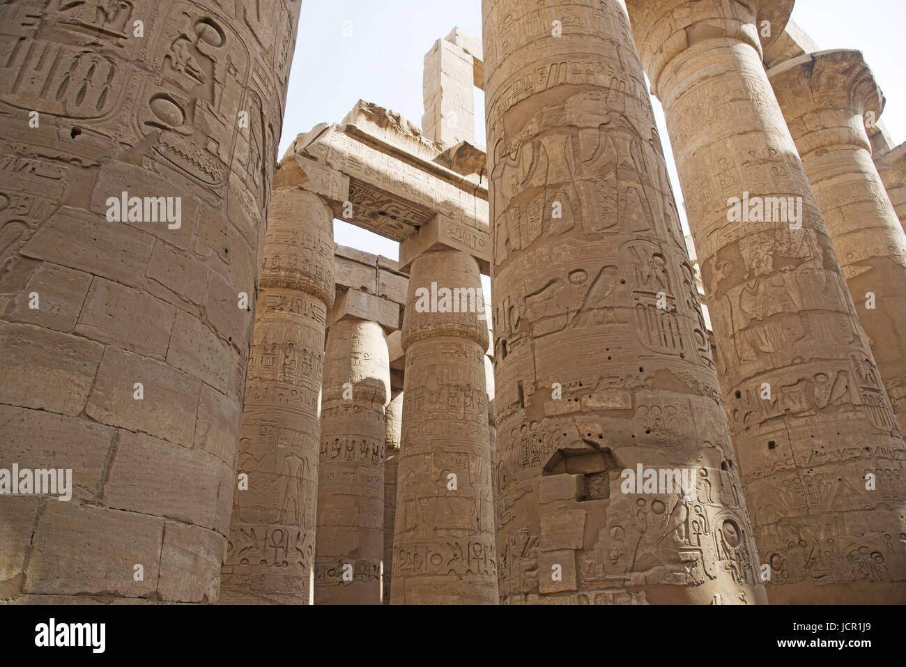 Los pilares tallados, construido en piedra caliza amarilla, vista de la gran sala hipóstila salen en el recinto de Amón Re, situado en el complejo del templo de Karnak, comprende una Foto de stock