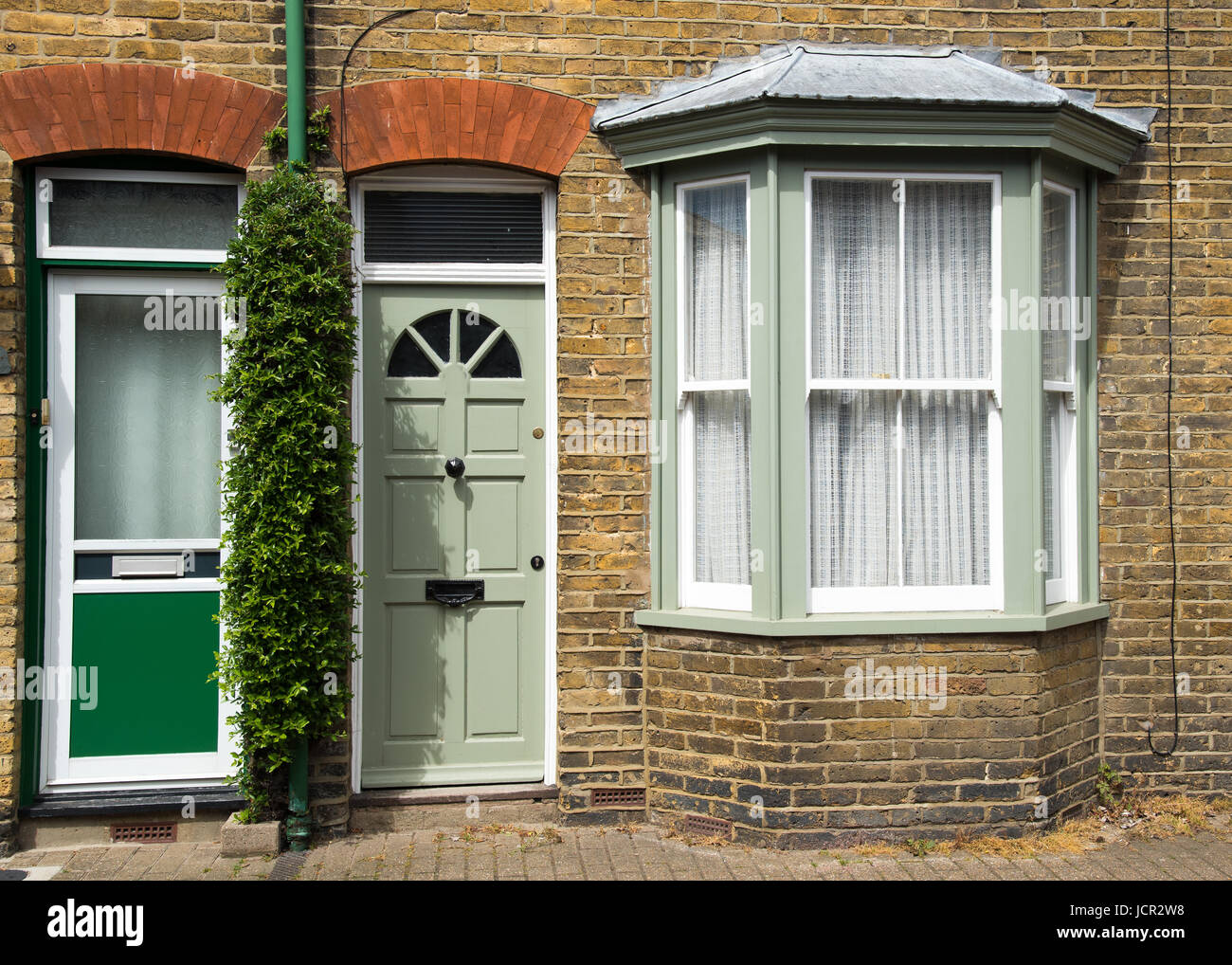 Casa Inglesa tradicional entrada frontal verde con puertas cerradas y  ventanas blancas Fotografía de stock - Alamy