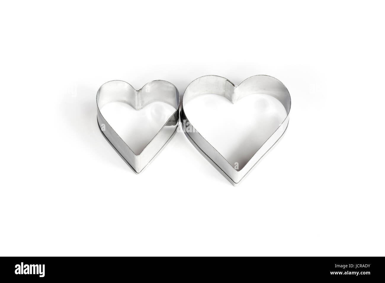 Dos corazones metálicos sobre fondo blanco. Foto de stock
