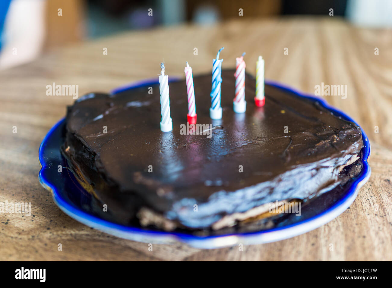 Simple cuadrado pequeño pastel de cumpleaños de chocolate con cinco  coloridas velas Fotografía de stock - Alamy