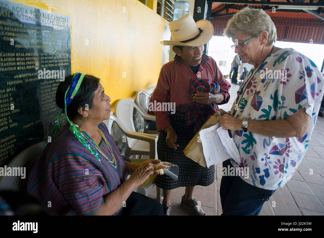Un voluntario las conversaciones con los pueblos indígenas en la clínica gratuita proporcionada NPO local en San Antonio Palopó, Sololá, Guatemala. Foto de stock