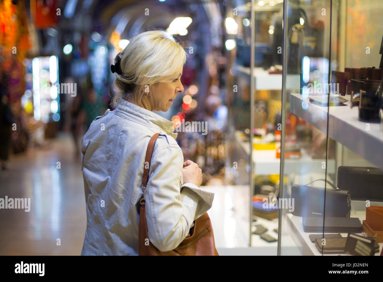 Mujer de mediana edad en escaparate de compras en el Gran Bazar de Estambul, Foto de stock
