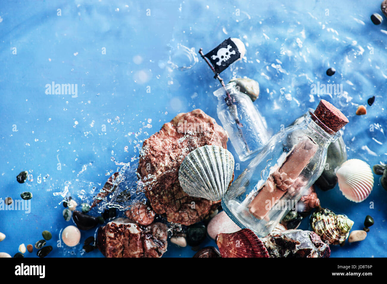 Mensaje pirata en una botella de vidrio en aguas poco profundas con rizado de seawave. todavía la vida submarina. Foto de stock