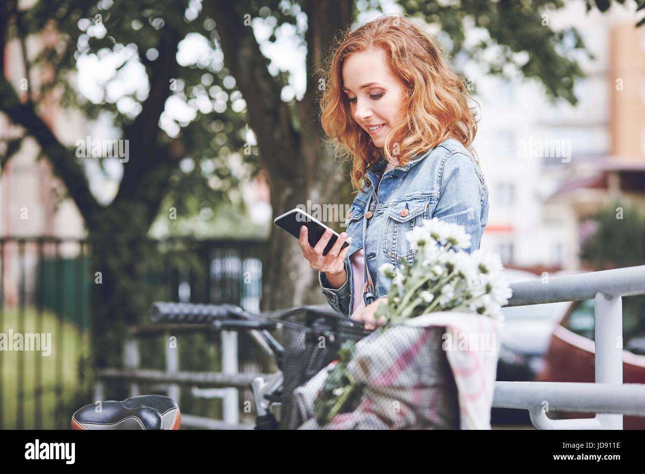 Mujer con teléfono móvil relajante después del ciclismo Foto de stock