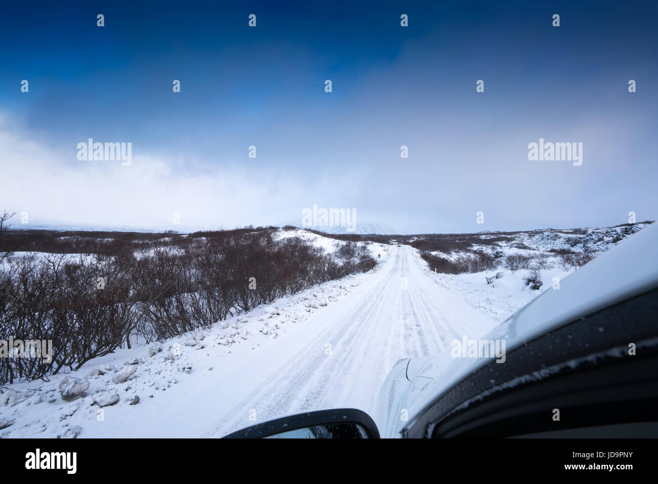 La conducción del vehículo a través de la carretera cubierta de nieve, la disminución de la perspectiva, Islandia, Europa. Islandia naturaleza frío invierno 2017 Foto de stock