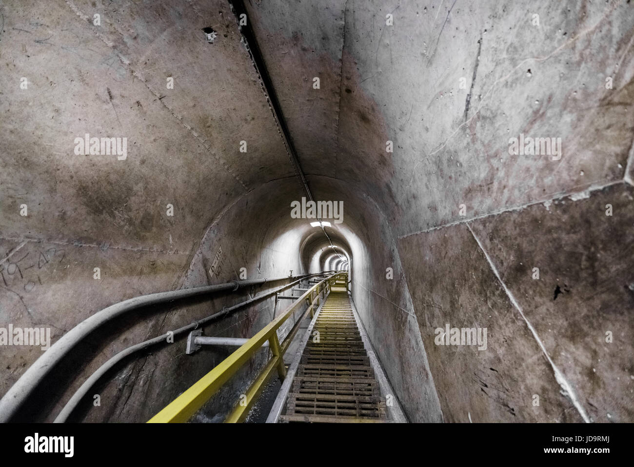 Vista de los pasos dentro del túnel de hormigón industrial vacío, disminuyendo la perspectiva. Foto de stock
