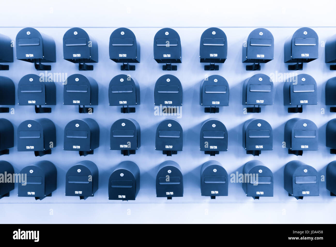 Los buzones en residencial para informaciones y noticias con su número de habitación, en tonos de azul. Foto de stock