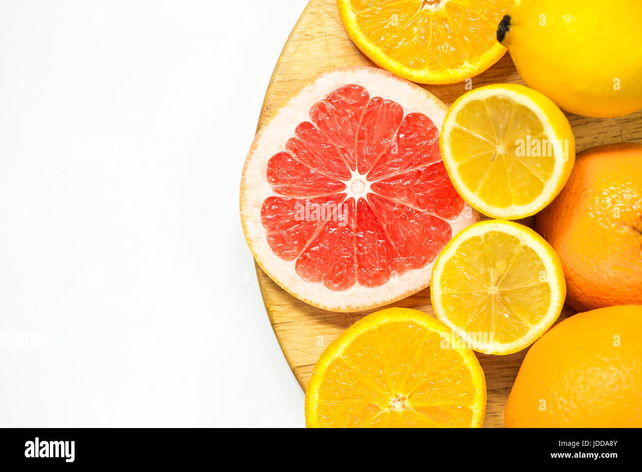 La vitamina C frutas - limón, naranja y pomelo cortes en woden placa de corte sobre fondo blanco. Foto de stock