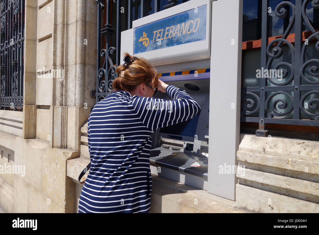 Turista con Telebanco retirada de efectivo en el norte de España Santander maching mujer haciendo una retirada de efectivo en cajero automático Foto de stock