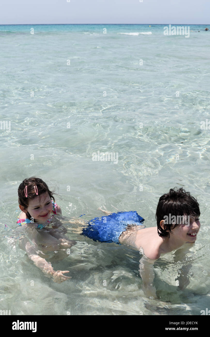 Chico y chica (hermano y hermana) jugando en el mar Foto de stock