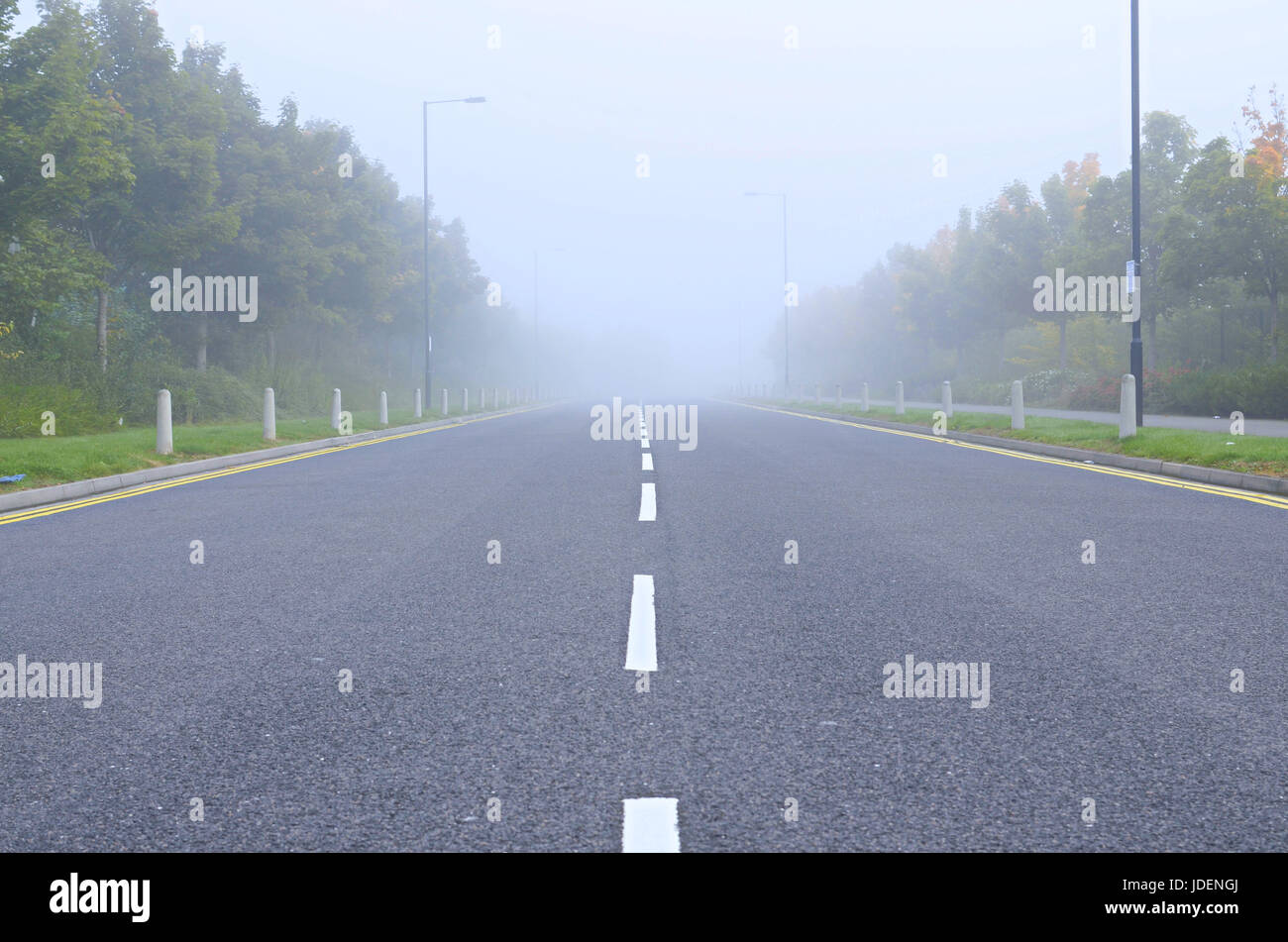 Carretera asfáltica durante condiciones de niebla, poca visibilidad. La industria estate road en Inglaterra Foto de stock