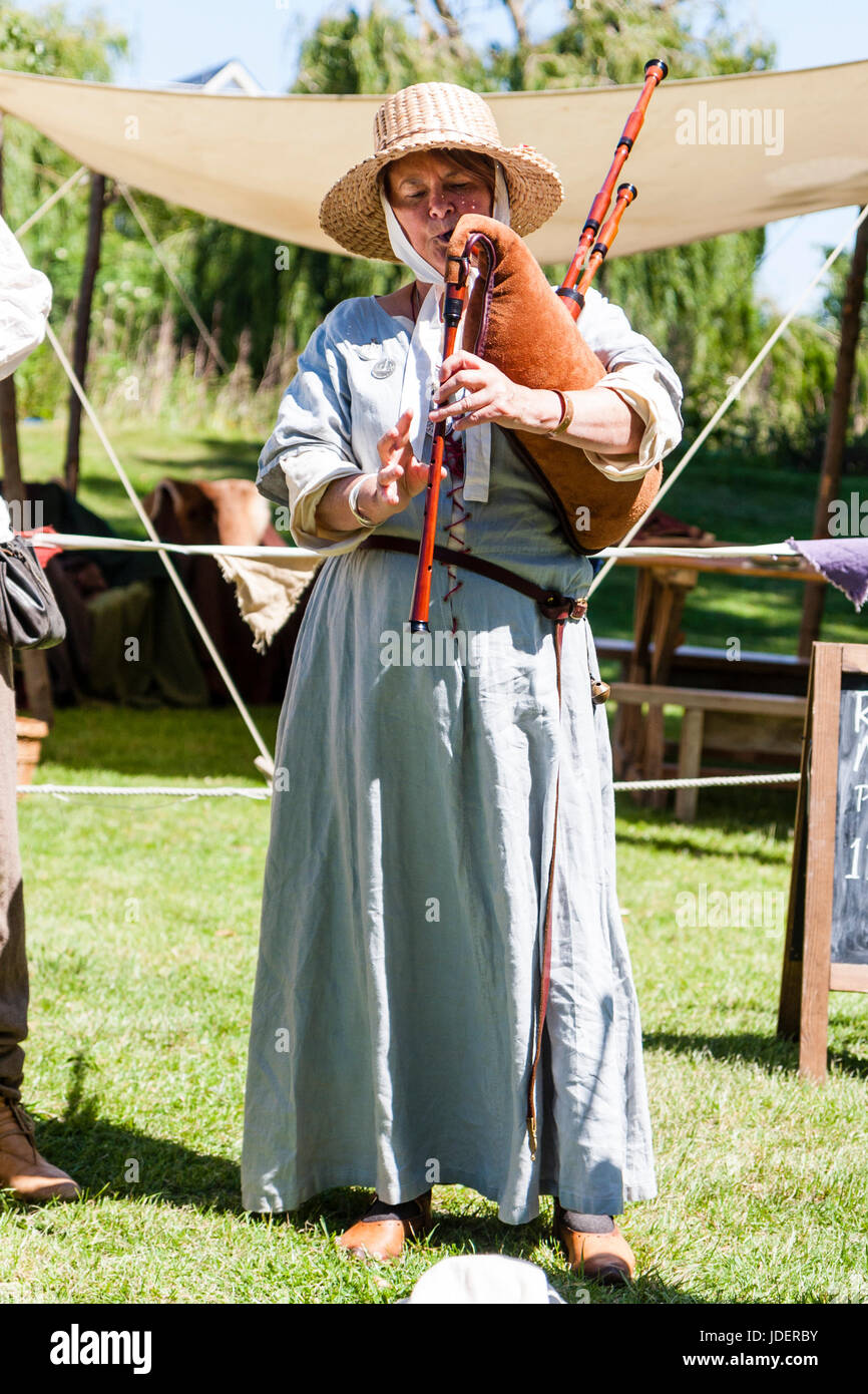 Re-promulgación evento medieval, mujer madura, vestida como músico juglar  medieval, de pie, vestido con sombrero de paja de ala ancha tocando la  gaita Fotografía de stock - Alamy