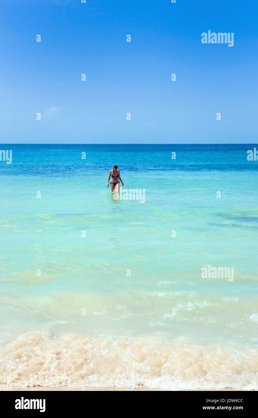Mujer de mar en la playa en frente de las cataratas del río Dunn, Jamaica Foto de stock