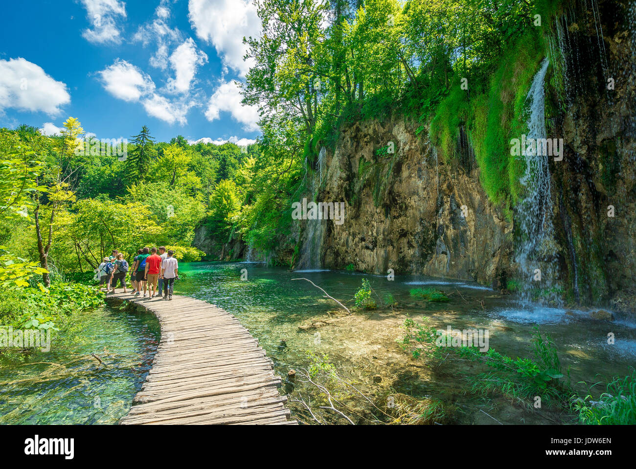 Hay turistas que caminan a lo largo de la rambla de madera los vientos alrededor de los Lagos de Plitvice, Parque Nacional Foto de stock